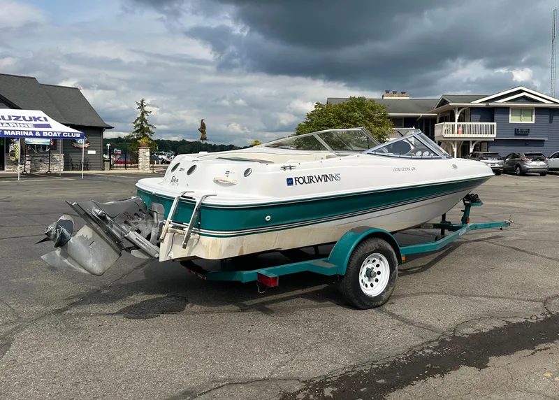 Slide: The Image of 1997 Four Winns Horizon QX boat on trailer in marina parking lot. - 6