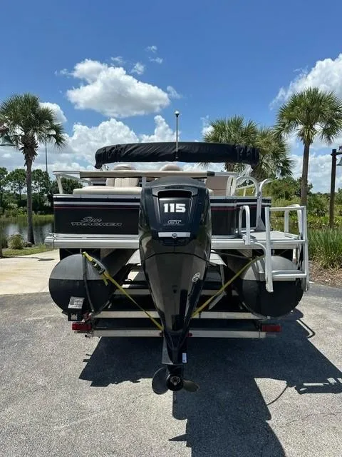 Slide: The Image of 2015 Sun Tracker Fishing Barge 24 with 115 HP motor, parked under clear blue sky. - 3