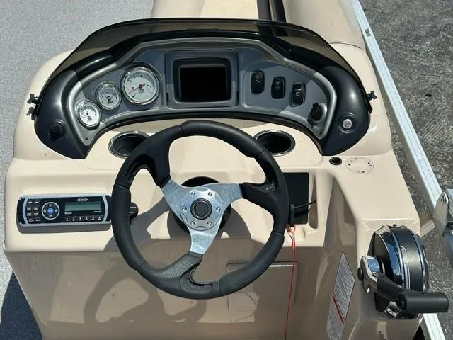 Slide: The Image of 2015 Sun Tracker Fishing Barge 24 dashboard with steering wheel and gauges. - 4