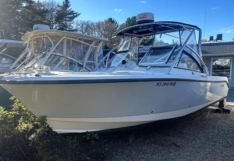 Slide: The Image of 2011 Edgewater 245 CX boat on display, parked outdoors, clear sky background. - 0