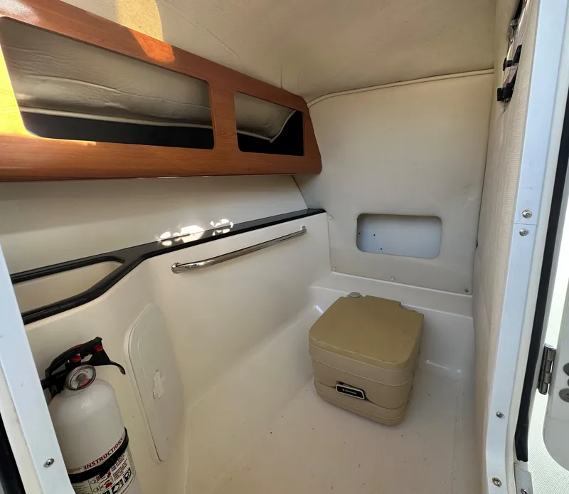Slide: The Image of Interior cabin of 2011 Edgewater 245 CX boat with portable toilet and fire extinguisher. - 13