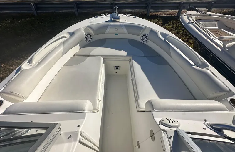 Slide: The Image of 2011 Edgewater 245 CX boat interior with white seating and speakers. - 2