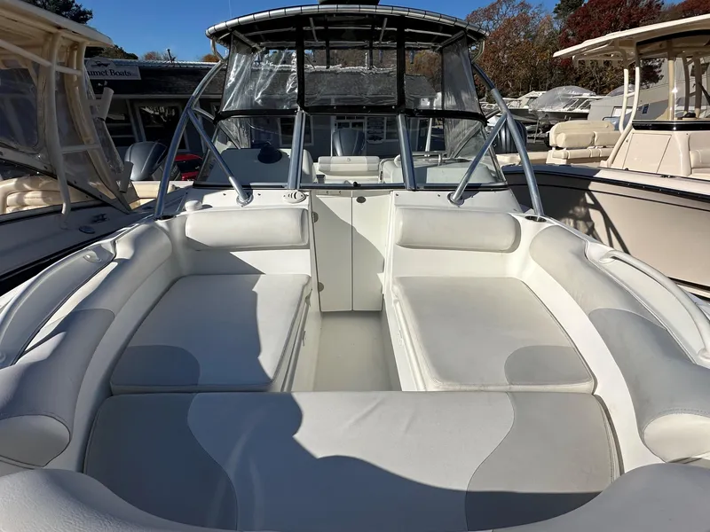 Slide: The Image of 2011 Edgewater 245 CX boat with spacious white seating and clear canopy. - 3