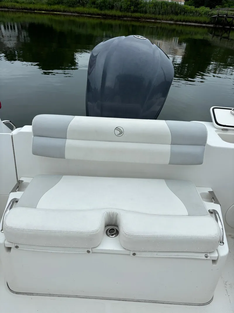 Slide: The Image of Edgewater 245 CX 2011 boat with cushioned seating and outboard motor. - 8