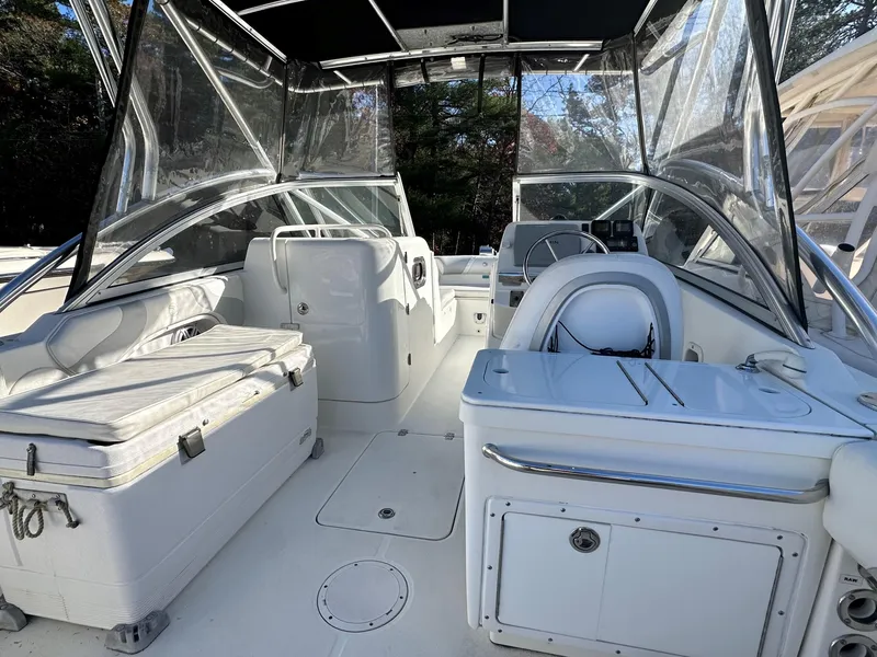 Slide: The Image of Edgewater 245 CX 2011 boat interior with seating and helm, featuring clear canopy. - 9