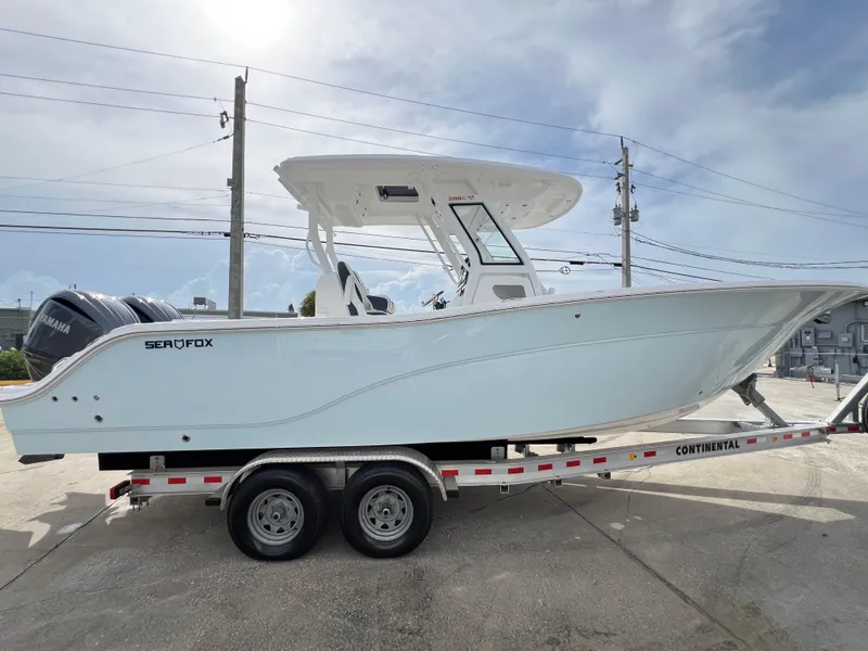 Slide: The Image of 2025 Sea Fox 288 Commander boat on trailer, side view, under clear sky. - 8