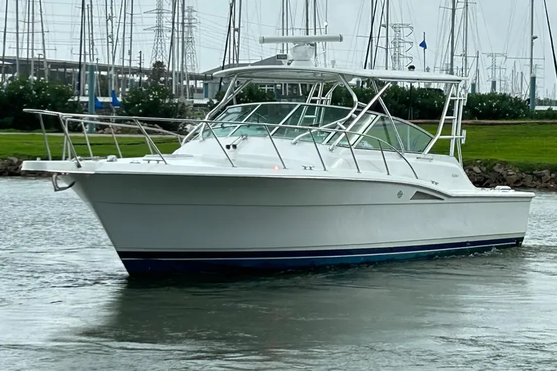The Image of 1996 Hatteras 39 Sport Express boat cruising in a marina with sailboats in the background. - 0