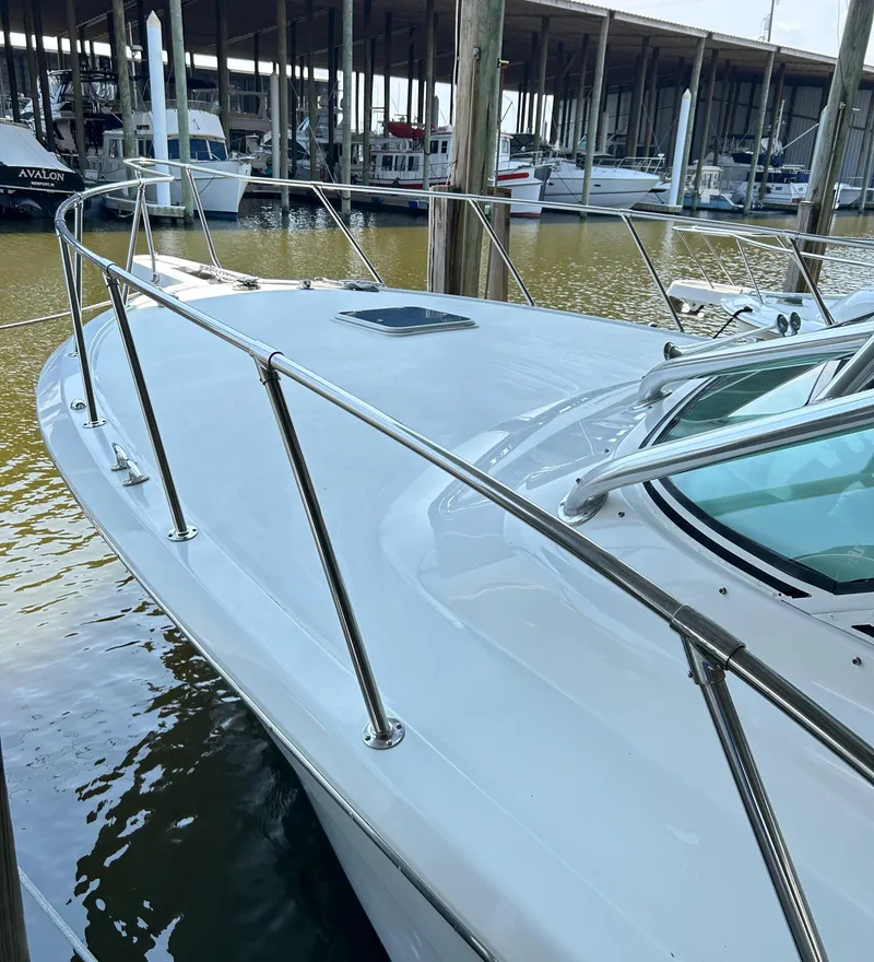 Slide: The Image of 1996 Hatteras 39 Sport Express docked at marina, showcasing sleek design and sturdy railings. - 10