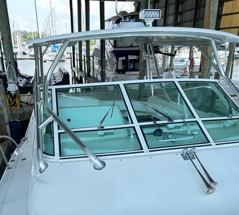 Slide: The Image of 1996 Hatteras 39 Sport Express boat docked in a marina, featuring a sleek windshield design. - 13