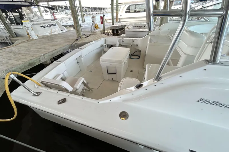 Slide: The Image of 1996 Hatteras 39 Sport Express boat docked, featuring spacious seating and clean white deck. - 18