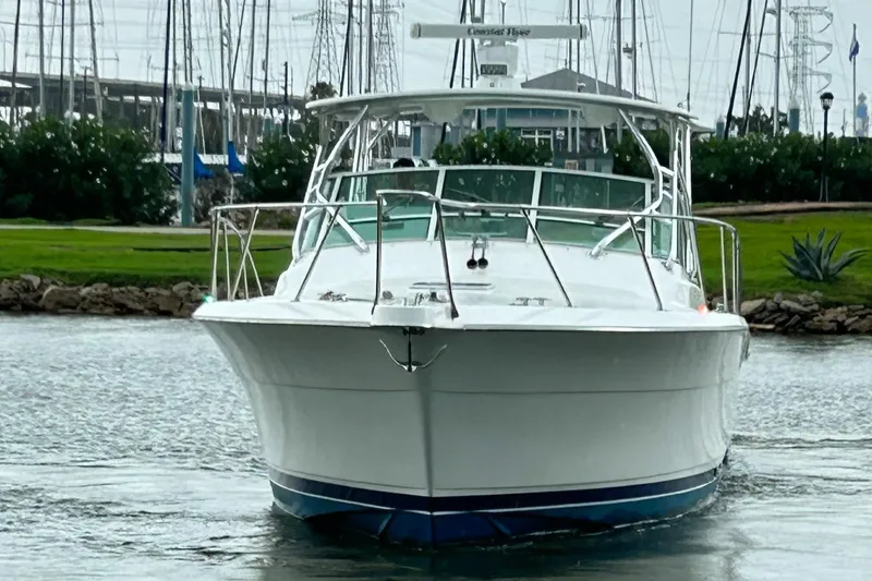 Slide: The Image of 1996 Hatteras 39 Sport Express boat on water, marina background, front view. - 2