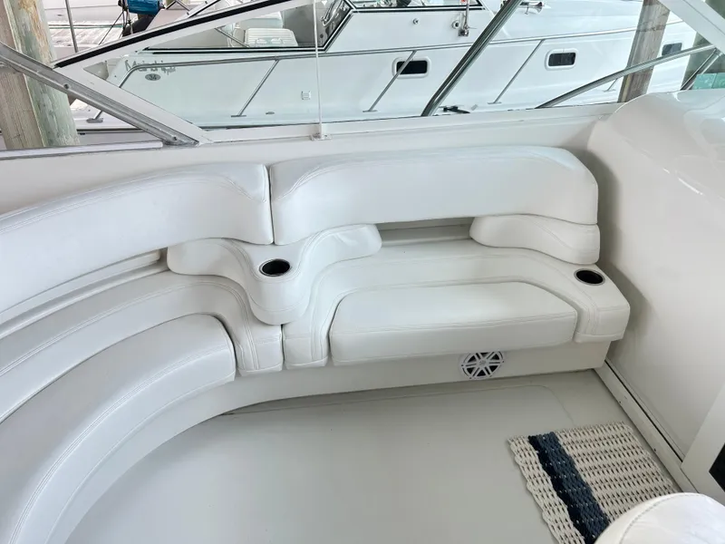 Slide: The Image of 1996 Hatteras 39 Sport Express interior with white curved seating and cup holders. - 23