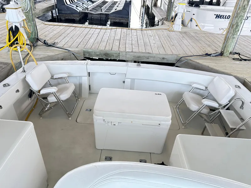 Slide: The Image of 1996 Hatteras 39 Sport Express boat interior with white seating and cooler. - 24