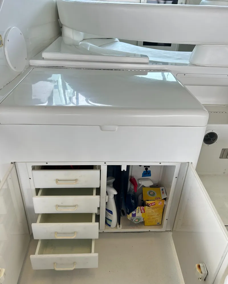 Slide: The Image of 1996 Hatteras 39 Sport Express storage area with drawers and cleaning supplies. - 26