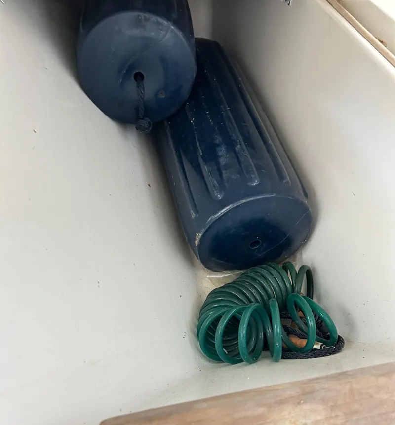 Slide: The Image of Boat storage compartment with fenders and coiled green rope, Hatteras 39 Sport Express 1996. - 31