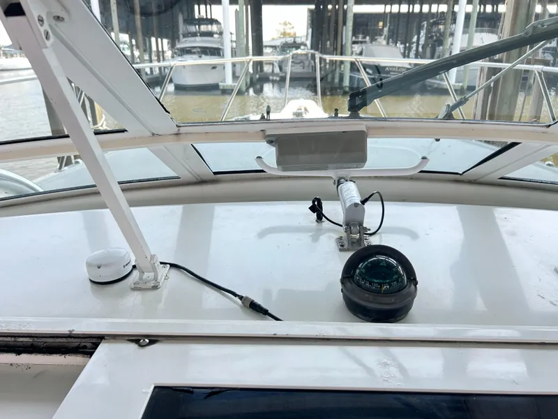 Slide: The Image of 1996 Hatteras 39 Sport Express helm with compass and marina view. - 33