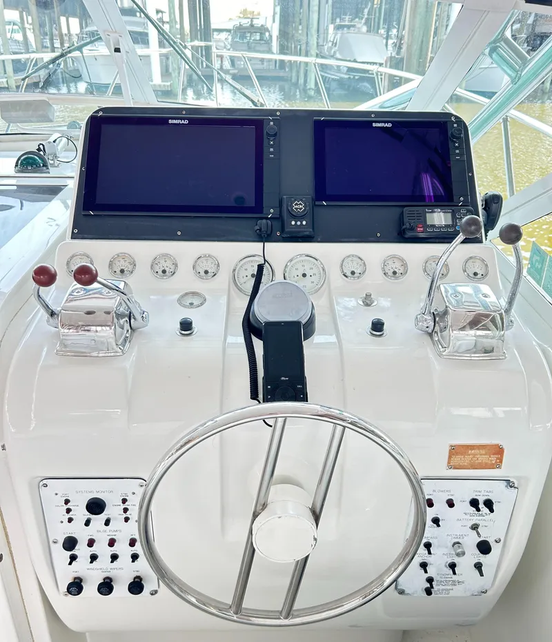 Slide: The Image of Control panel of 1996 Hatteras 39 Sport Express with dual screens and steering wheel. - 37