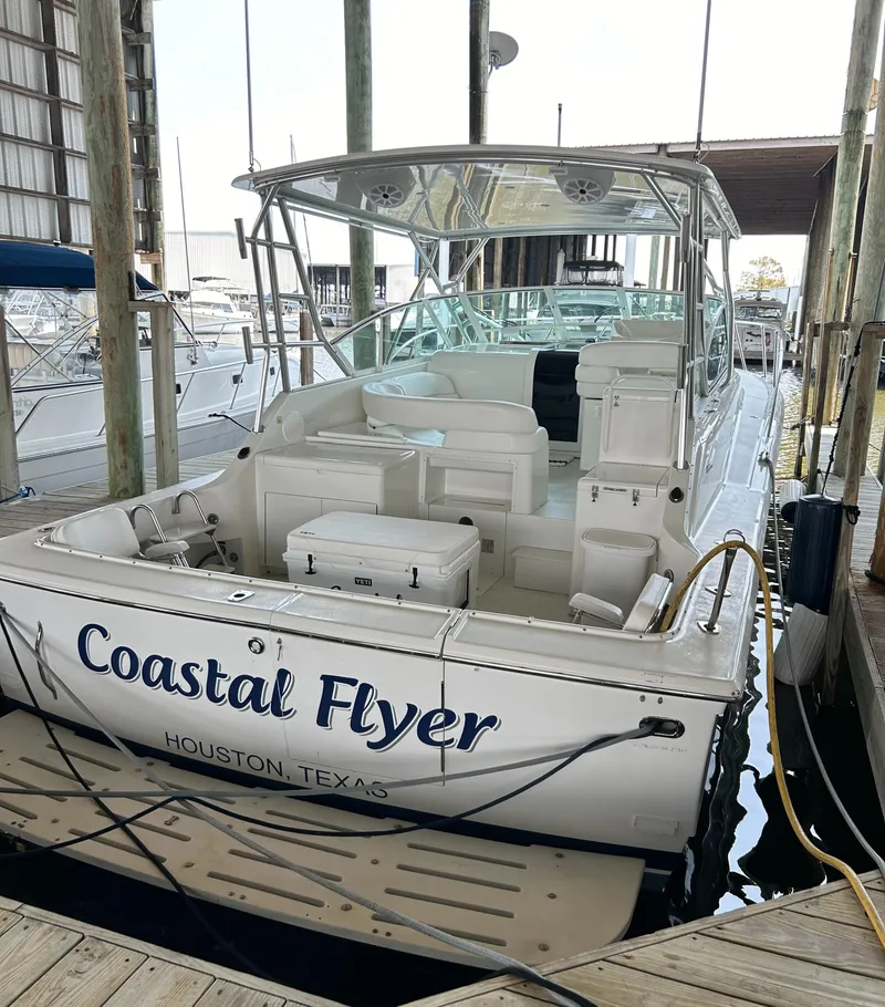 Slide: The Image of 1996 Hatteras 39 Sport Express docked, named "Coastal Flyer," in Houston, Texas marina. - 4