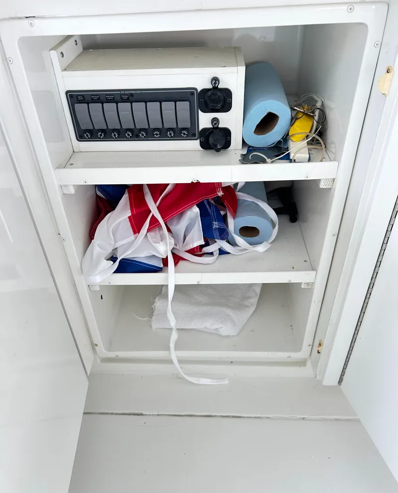 Slide: The Image of Storage cabinet on 1996 Hatteras 39 Sport Express with electrical panel and supplies. - 44