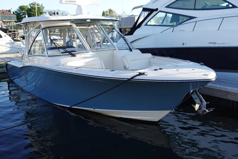 Slide: The Image of 2021 Grady-White Freedom 325 boat docked in marina, featuring sleek design and blue hull. - 0