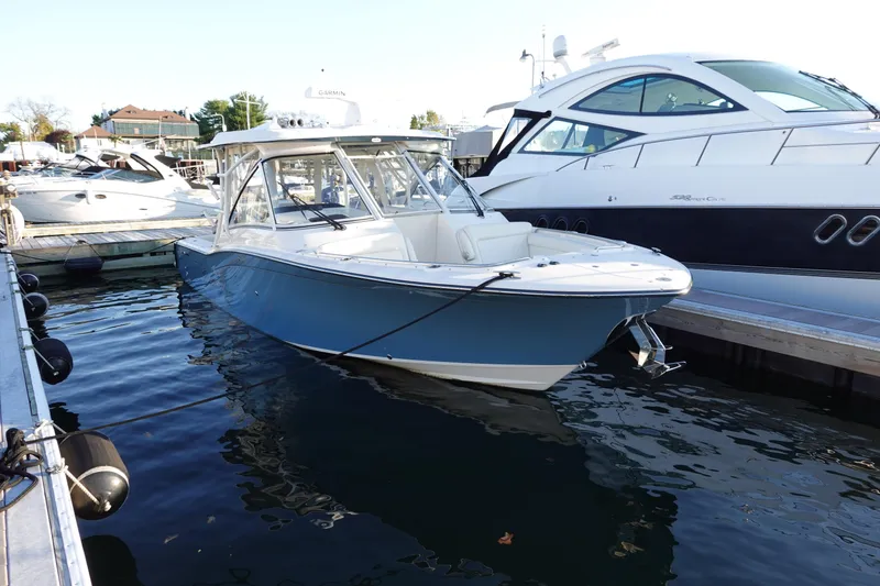 Slide: The Image of 2021 Grady-White Freedom 325 boat docked at marina, surrounded by other vessels. - 8