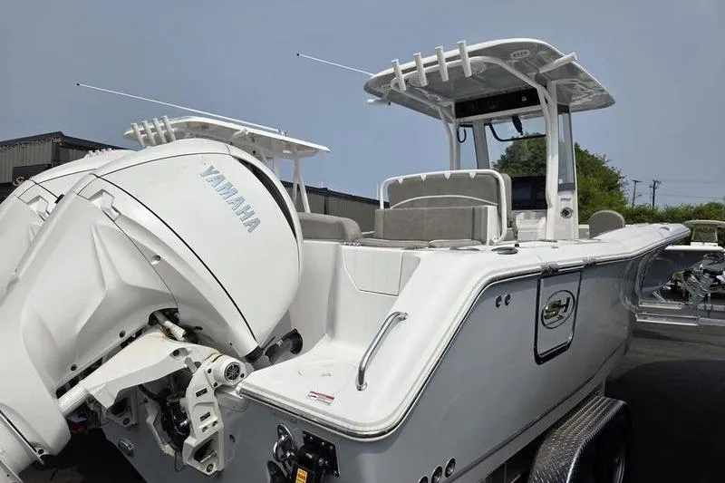 Slide: The Image of 2025 Sea Hunt Ultra 275 SE boat with Yamaha engine, docked outdoors. - 10