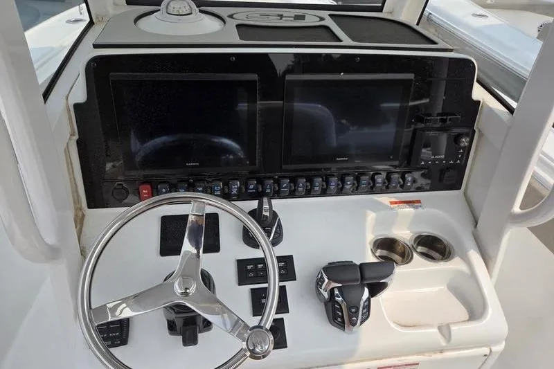 Slide: The Image of Dashboard of 2025 Sea Hunt Ultra 275 SE boat with steering wheel and controls. - 17