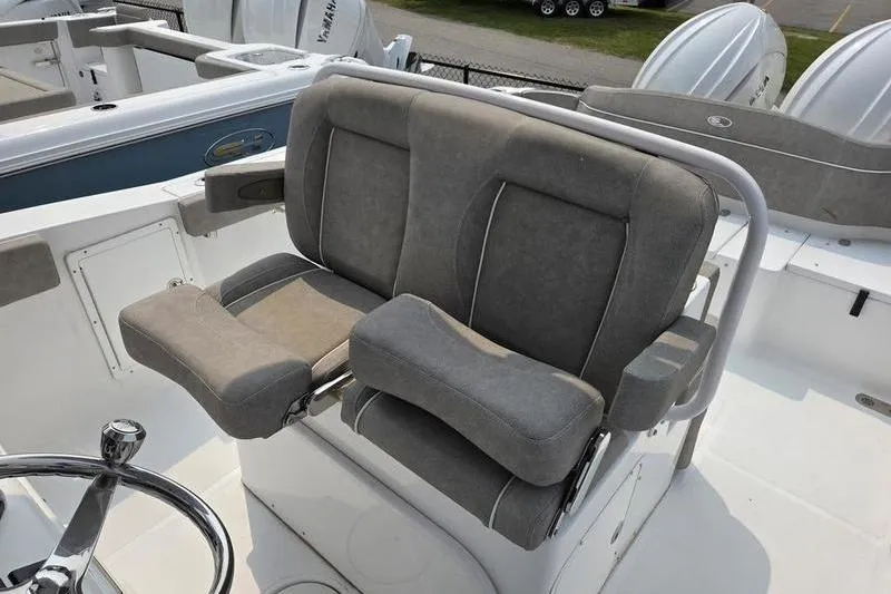 Slide: The Image of 2025 Sea Hunt Ultra 275 SE boat seating with gray upholstery and steering wheel. - 5