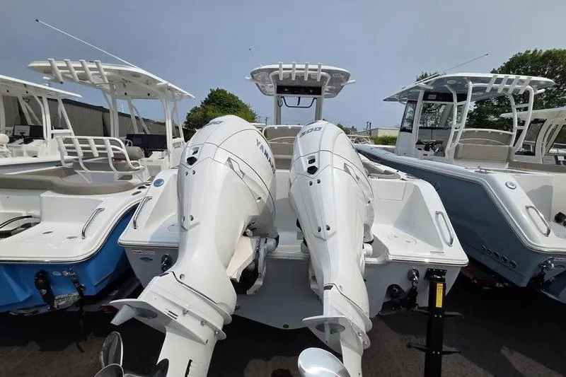 Slide: The Image of 2025 Sea Hunt Ultra 275 SE boat with dual outboard engines, docked alongside similar models. - 6