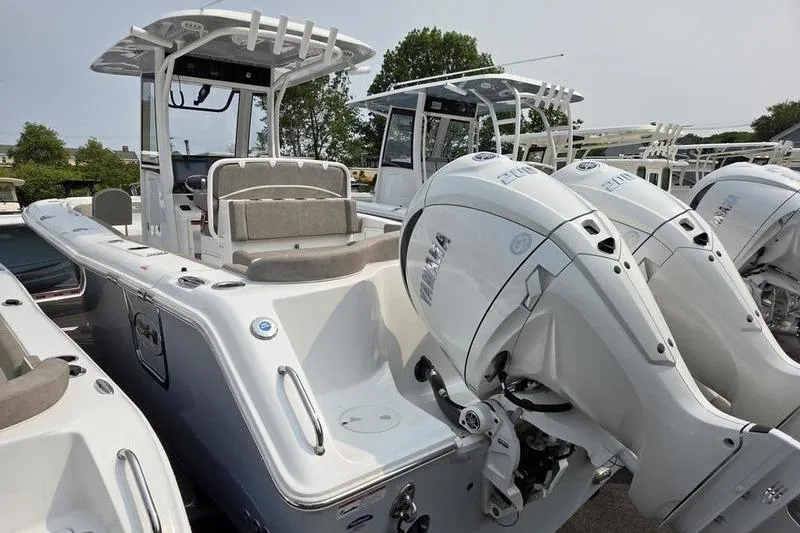 Slide: The Image of 2025 Sea Hunt Ultra 275 SE boat with dual outboard engines, docked outdoors. - 7
