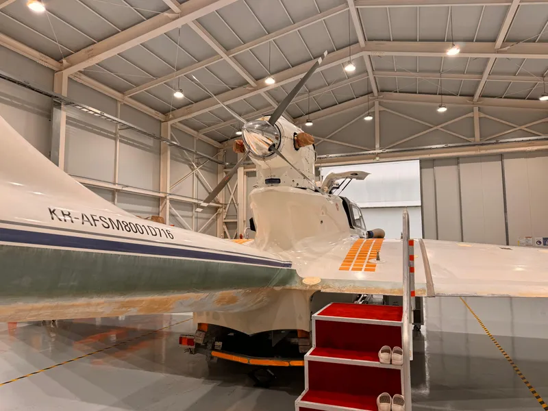 Slide: The Image of Aron M 80 aircraft in hangar, 2025 model, with visible tail and propeller. - 11