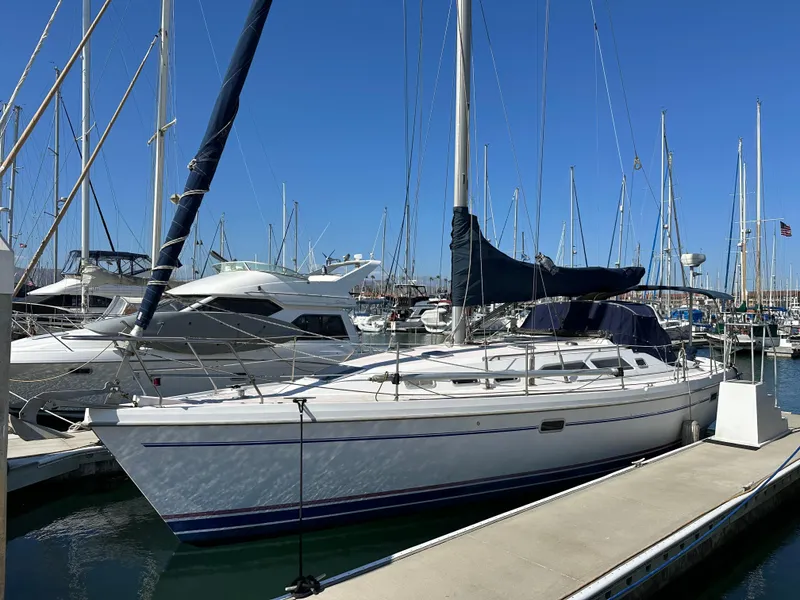 The Image of 1998 Catalina 380 sailboat docked in a marina under clear blue skies. - 0