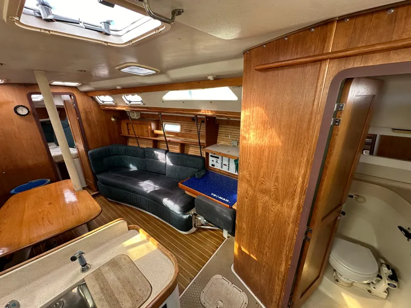 Slide: The Image of Interior of 1998 Catalina 380 sailboat with wood finish and cozy seating area. - 13