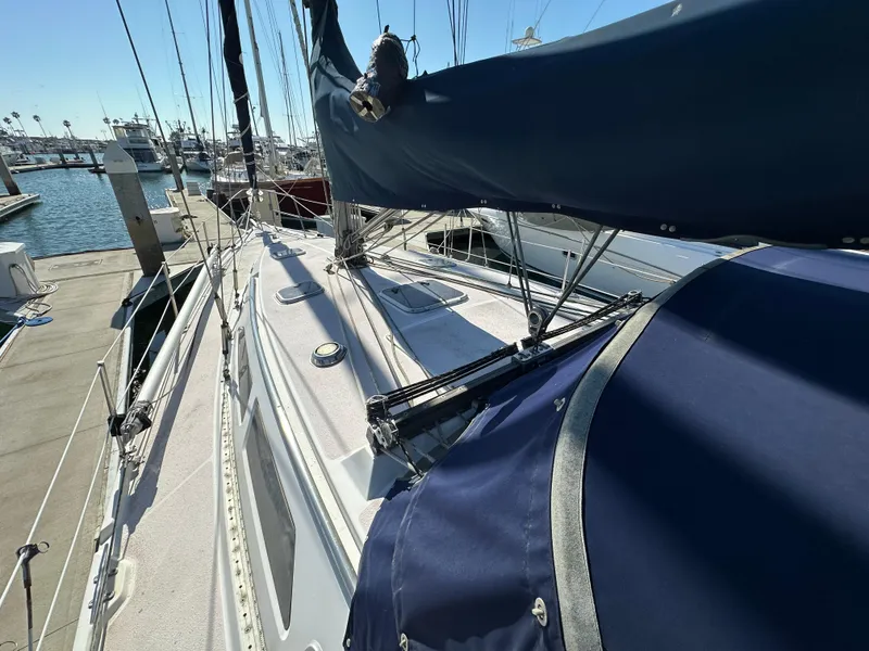 Slide: The Image of 1998 Catalina 380 sailboat docked at marina, featuring blue sail cover. - 2