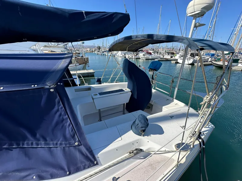 Slide: The Image of 1998 Catalina 380 sailboat docked in marina, featuring blue canvas covers. - 4