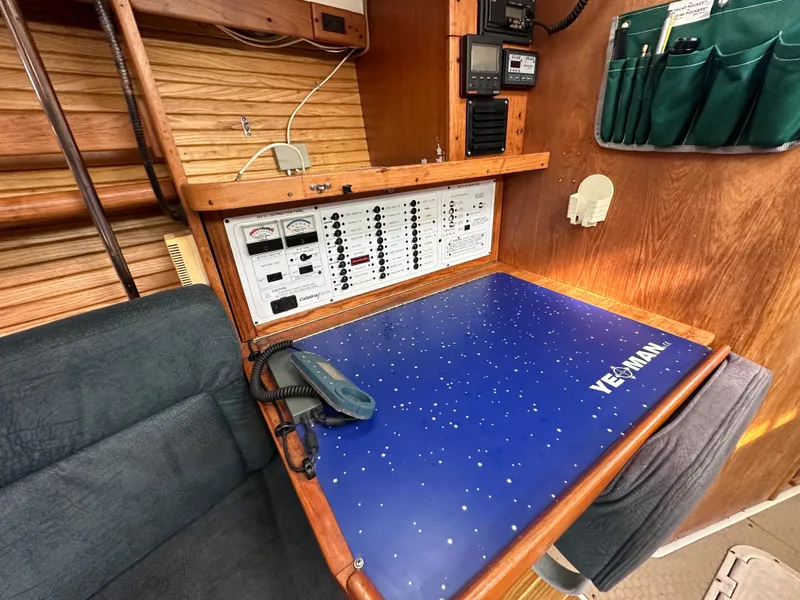 Slide: The Image of Navigation station in 1998 Catalina 380 sailboat with control panel and blue chart table. - 6