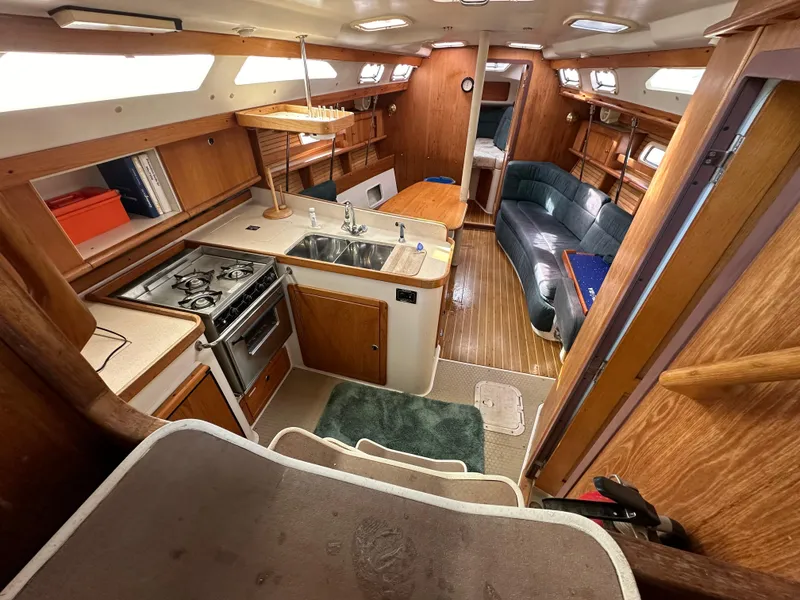Slide: The Image of Interior of 1998 Catalina 380 sailboat with kitchen, seating, and wood finishes. - 7