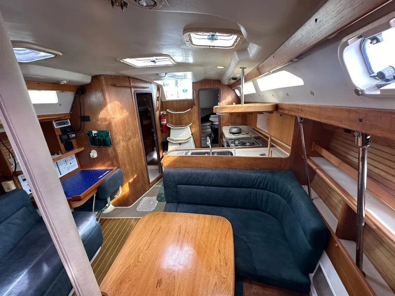 Slide: The Image of Interior of 1998 Catalina 380 sailboat with cozy seating and wooden finishes. - 9