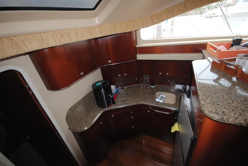 Slide: The Image of 2005 Sea Ray 390 Motor Yacht kitchen with wood cabinets and granite countertops. - 26