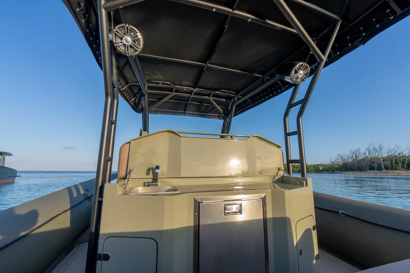 Slide: The Image of 2024 G-Tender DIECI boat interior with canopy, steering console, and calm water backdrop. - 34