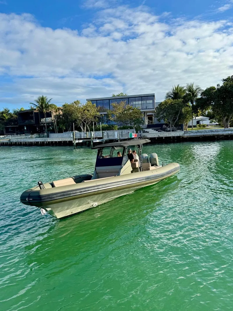 Slide: The Image of 2024 G-Tender DIECI boat cruising on clear green water near a modern waterfront property. - 7