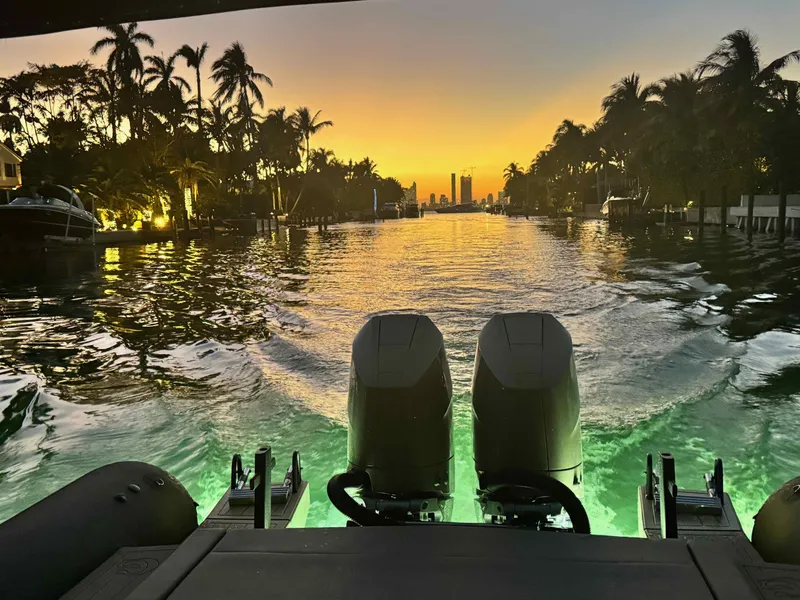 Slide: The Image of 2024 G-Tender DIECI boat cruising at sunset with illuminated water and palm trees. - 9