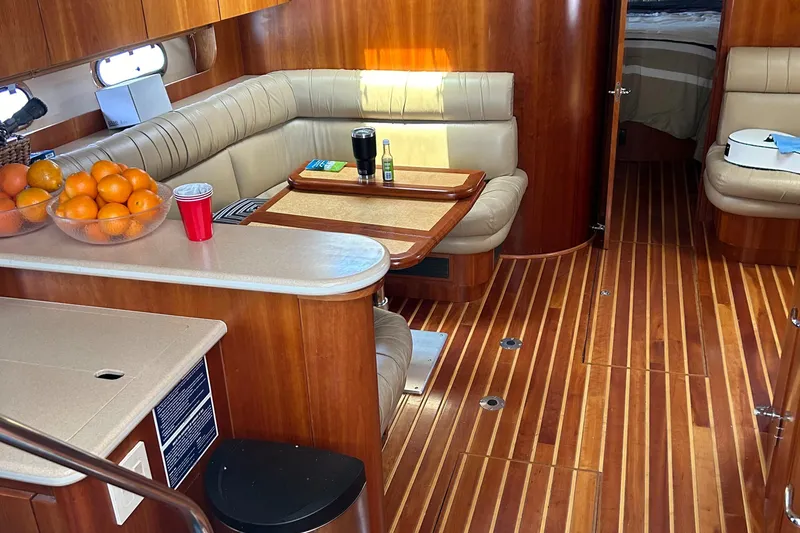 Slide: The Image of Interior of 2000 Tiara Yachts 5000 Express with wood flooring and cozy seating area. - 14