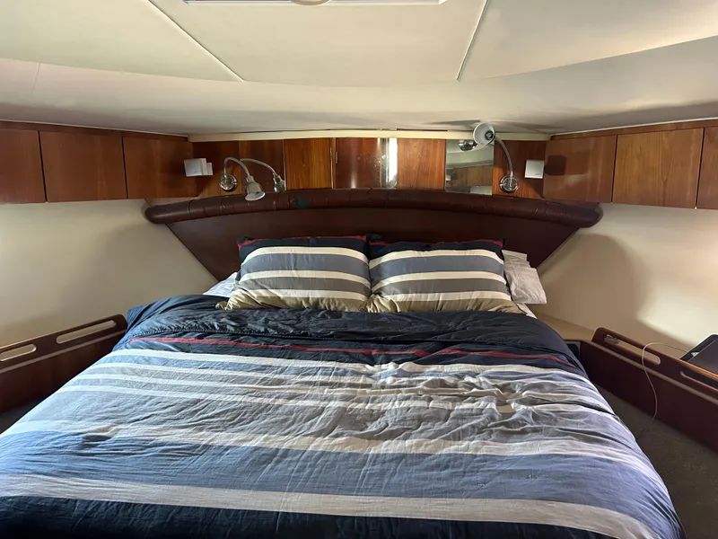 Slide: The Image of Luxurious bedroom interior of 2000 Tiara Yachts 5000 Express with striped bedding. - 17