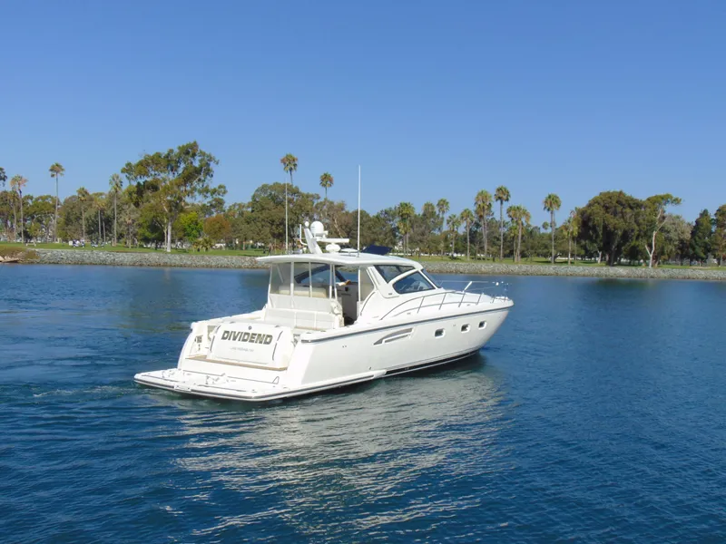Slide: The Image of 2000 Tiara Yachts 5000 Express cruising on a serene lake with palm trees. - 24