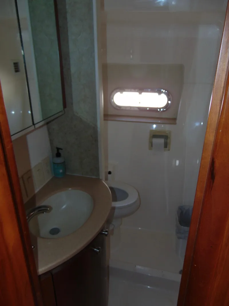 Slide: The Image of Bathroom interior of 2000 Tiara Yachts 5000 Express, featuring sink and porthole window. - 26