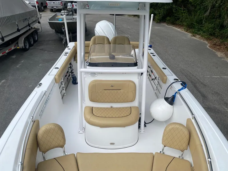 Slide: The Image of 2022 Sportsman Heritage 231 boat with tan seating, docked in a marina. - 10