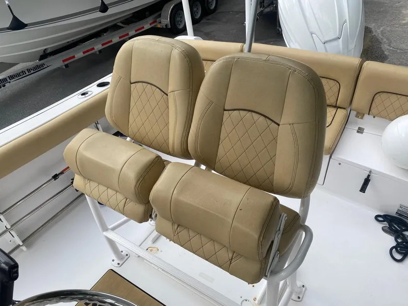 Slide: The Image of 2022 Sportsman Heritage 231 boat with tan cushioned seating and white deck. - 11