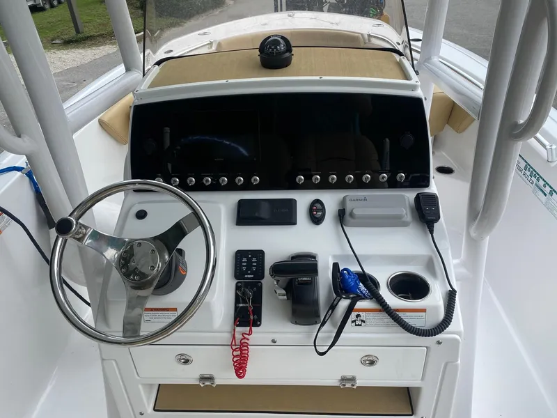 Slide: The Image of 2022 Sportsman Heritage 231 boat dashboard with steering wheel and navigation controls. - 7