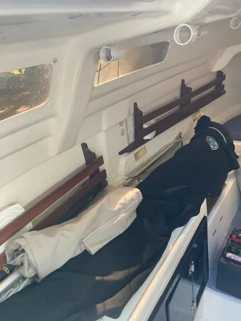 Slide: The Image of Interior of a 1997 MacGregor 26 X sailboat, showing storage and seating area. - 10